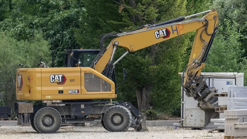 Колёсный экскаватор Cat M318 с гидроножницами на стройплощадке