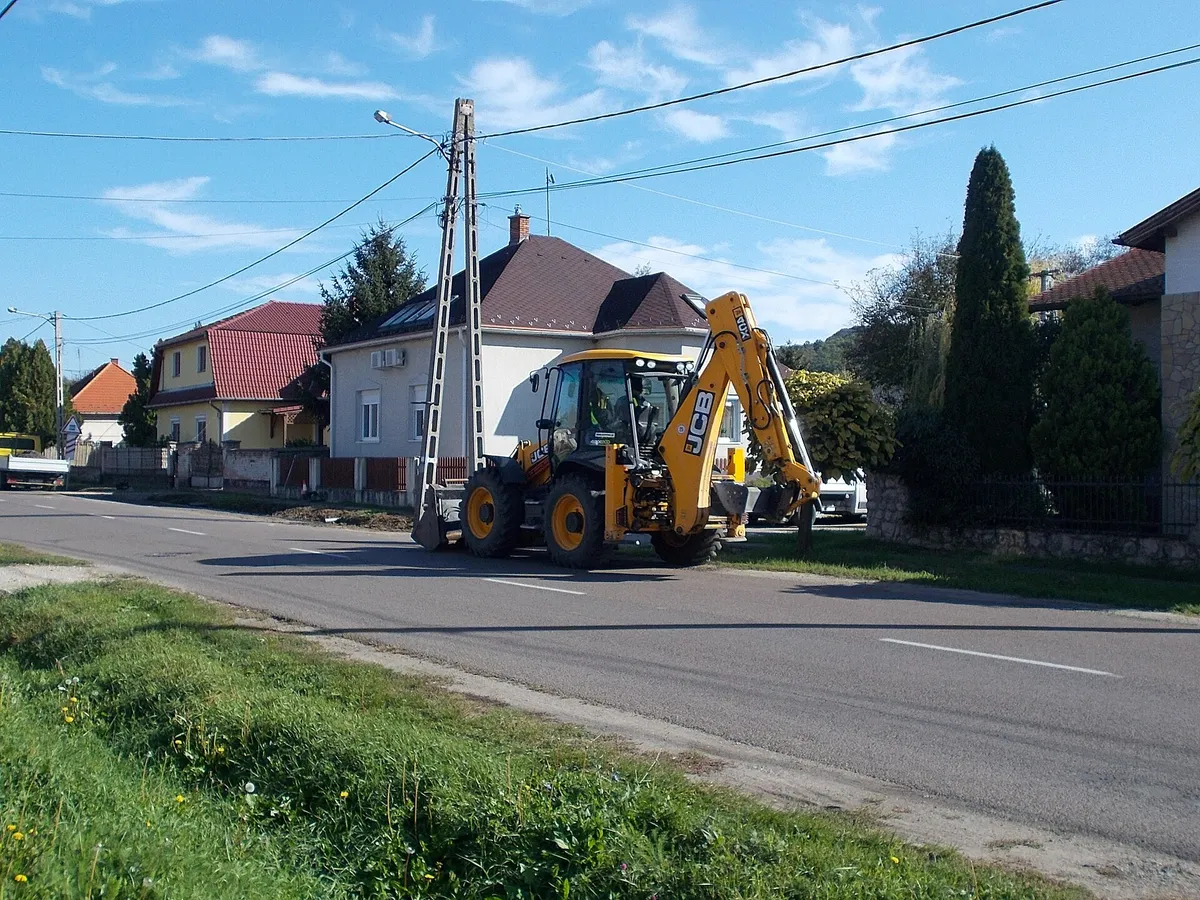 JCB 4CX на дороге со сложенной стрелой